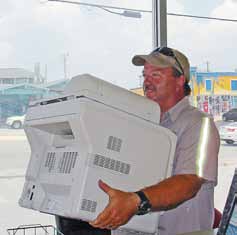 After two years of practice, employees of Atlantic Beach, N.C., have the protocols for recycling and buying green down. Recently, the town clerk’s printer went bad and employees used EPEAT comprehensive environmental ratings to purchase a new one through a register recycler. The photo shows Richard Lee hauling the old printer off to recycling. (Photo provided)