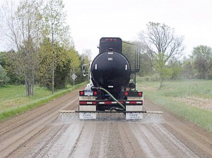 A tanker sprays calcium chloride on the road. Fifty-six percent of respondents in a recent dust control methods survey have found success using CaCl and flakes. (Photo provided)
