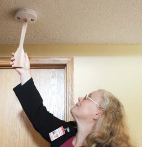 Amanda Swenson demonstrates a simple way to test a smoke detector