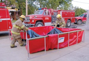 Local firefighters take advantage of Husky Portable Containment’s Easy Lift Handles for portable water tanks. (Photo provided)