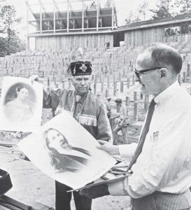 Kermit Hunter, right, author of “The McIntosh Trail,” looks at artistrenditions of William and Susanna McIntosh with Chief W.E. “Dode” McIntosh, their great-great-grandson. In the background, workers finish up construction of the Peachtree City Amphitheater, which hosted Hunter’s play as its inaugural production. (Photo by Glen Allen)