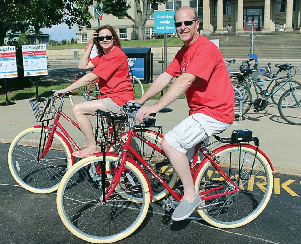 Jim and Melissa Patterson from Stark County, Ohio, test out the city’s bike share program, which is currently in its second year. This city’s program is unique because it allows residents to use their library cards to rent a bicycle instead of a credit card. (Photo provided)