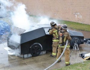 During a training exercise, two firefighters practice putting out an electric vehicle fire. (Photo provided)