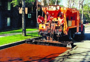 Slurry Seal coating and micro-surfacing have been touted as versatile and low-cost applications that can extend the life of city streets by five to seven years. Both petroleum-based emulsion products are mixed with a fine chip aggregate and spread in thin layers to fill cracks and ruts. (Photo provided)