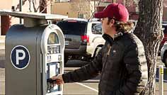 Customer at a solar-powered meter. In February the city bet on the sun to power the new multi-space, wireless parking technology option. (Photo provided)