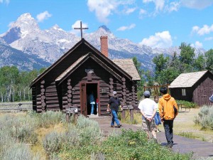 Visitors approach the Chapel of Transfiguration at Grand Teton National Park, Wyoming. Fewer employees at national parks have meant longer lines at entry stations, reductions in the daily hours of operation and other cutbacks. (Photo courtesy National Park Service)