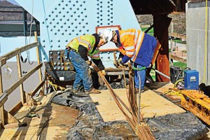 Crews prepare a nearly half-mile long truss for installation over the Ohio River this spring. The new Milton-Madison Bridge was moved along steel rails and plates and into place. (Photo by Charlie Gannon, Courtesy/Walsh Construction)