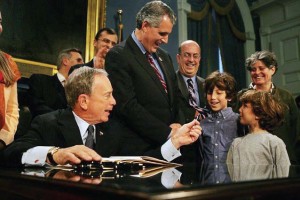 Laurie Kerr, far right, watches as Mayor Michael Bloomberg prepares to sign the Greener Greater, Greater Buildings Plan bill, which targets energy efficiency in large, existing buildings. (Photo provided)