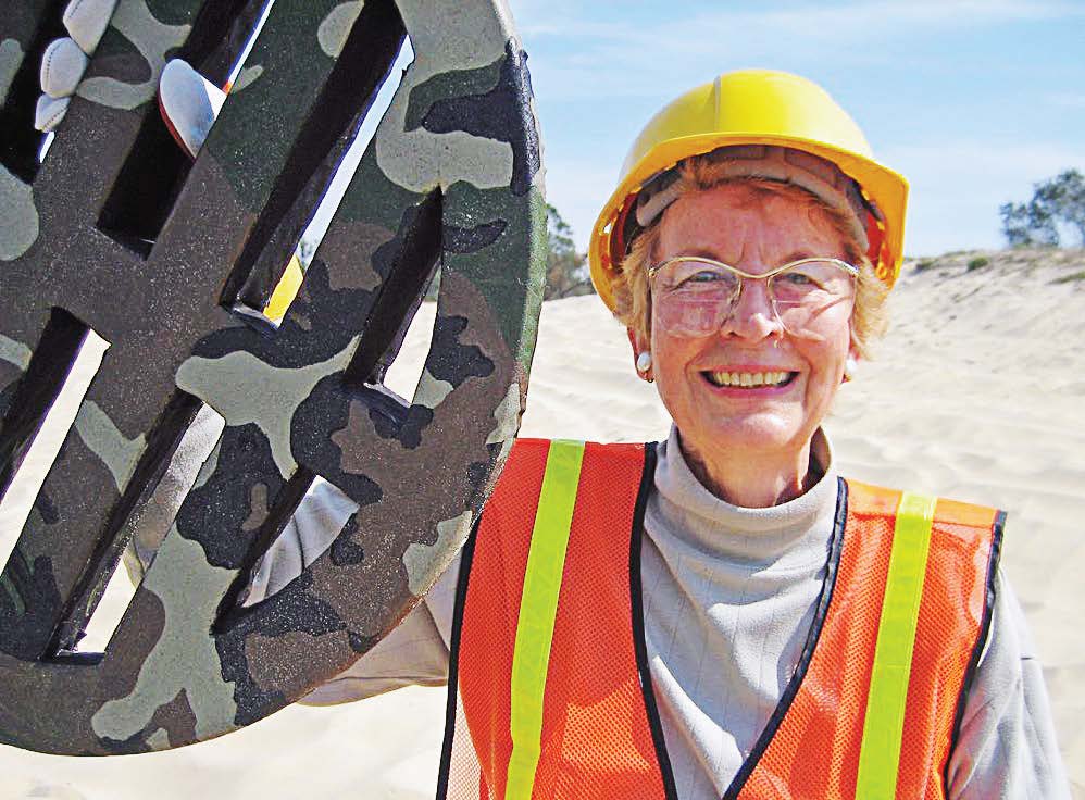 Artist Bobbi Mastrangelo holds one of her decorative manhole covers