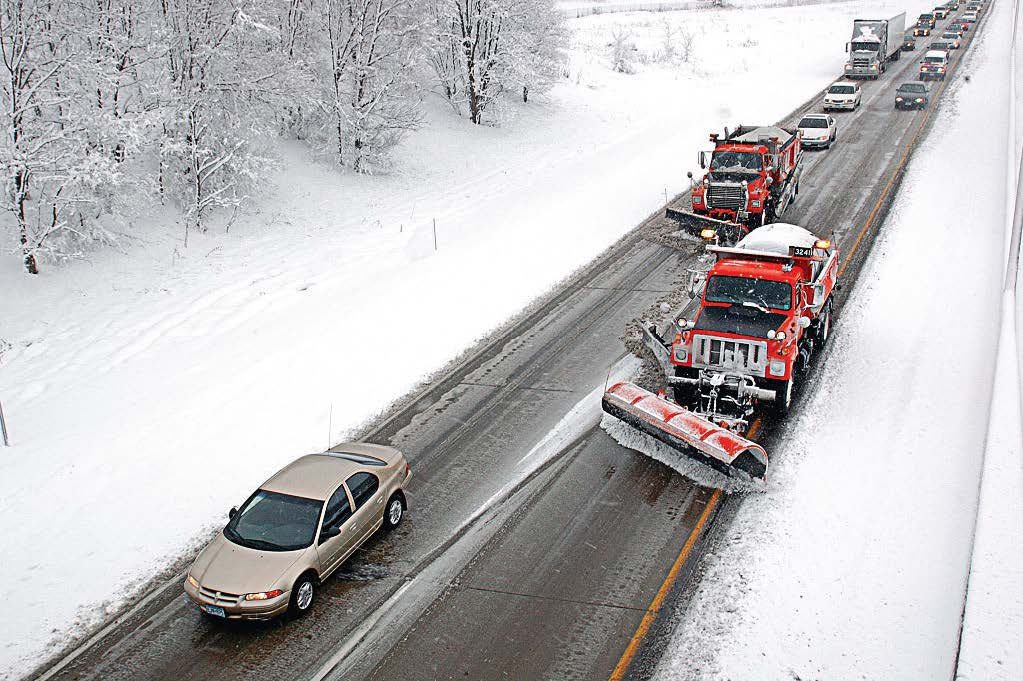 Minnesota Department of Transportation snowplow trucks clear a stretch of road with a string of motorists behind them. Many states focus on educating the public early in the season on safe winter driving habits, including about how to drive when near snowplows. (Photo provided)