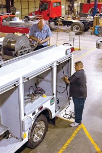 Two Southeast Apparatus crew members work on the wiring and plumbing for a 2015 Ford Rescue for Austin Tracy Fire Department in Kentucky. (Photo provided)