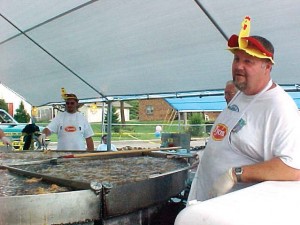 Volunteers man a giant deep fryer at the World Chicken Festival in London, Ky.