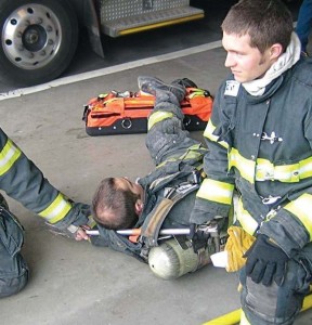 Placing a halligan or axe handle through the SCBA shoulder straps is fast and allows two firefighters to spread out so they can drag the down firefighter without bumping into each other, making the drag more effective.