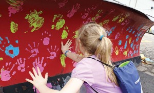 Many hands make light work of painting a snowplow in Lake in the Hills during a public open house last year. (Photo provided)