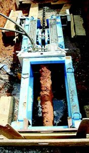 A piece of the old cured-in-place pipe is pulled back into the pit on the pulling side of the process. There is a steel plate that breaks the CIP as it gets to the machine. (Photo provided)