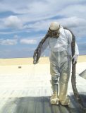A worker applies spray polyurethane foam onto a metal deck roof. (Photo provided by SPFA)