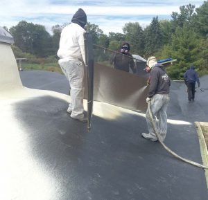 Pictured is a spray polyurethane foam roofing system being applied over a primed commercial roof. (Photo provided by SPFA)