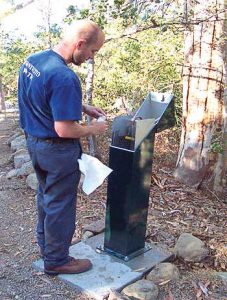 A technician draws a water sample from a water sampling station; water sampling stations reduce chances of receiving a false positive when testing water. (Photo provided)