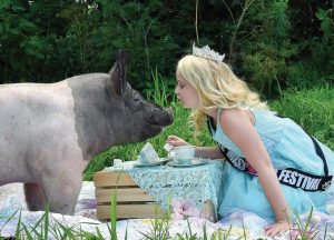 Little Miss World Festival Queen Lucy Kuepler hosts a tea party for her porky guest. (Photo provided by Larry Flannery)