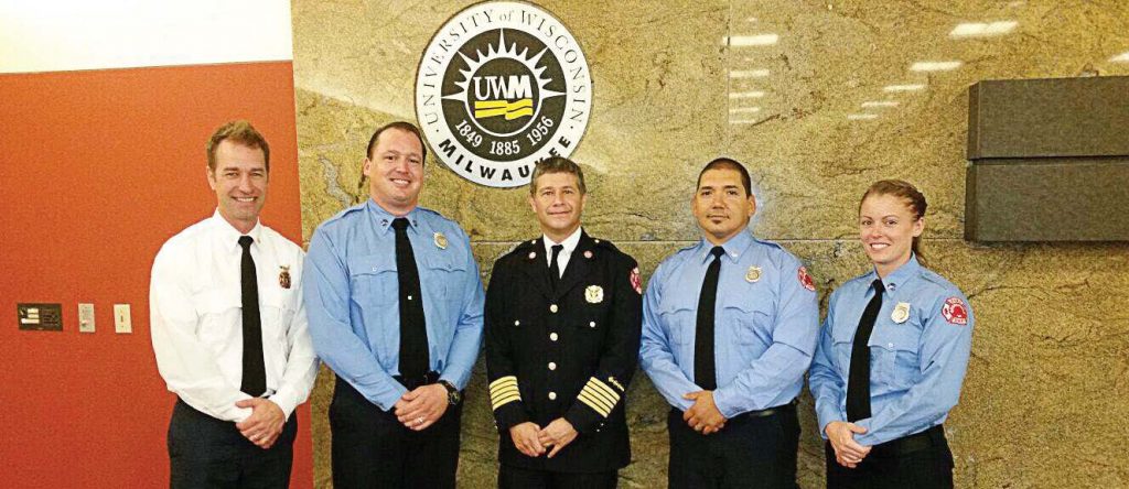 Chief Jon Cohn of Greenfield Fire-Rescue, center, stands with the department’s first four community paramedics at their graduation at the University of Wisconsin-Milwaukee. (Photo provided)