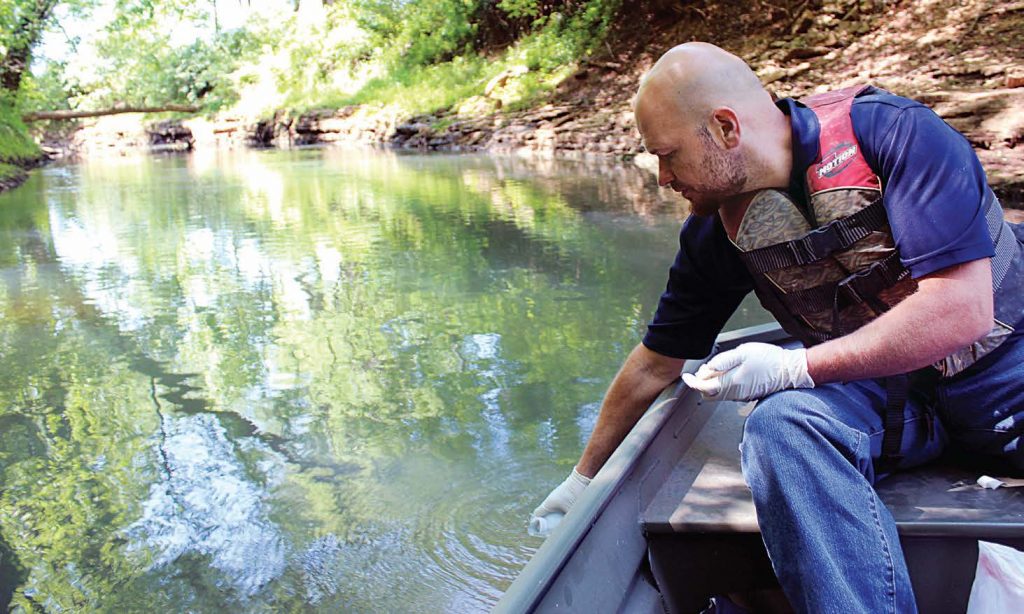 Matt Powell, city of Bowling Green, Ky., environmental manager, collects water samples to test from Jennings Creek. At one station there is now continuous monitoring when previously there had only been quarterly sampling. (Photo by Laura Harris)