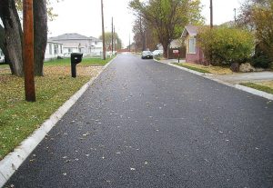 This “after” photo shows a recently installed porous asphalt road in the East Manawa neighborhood of Council Bluffs. The pores in the asphalt are visible in the photo. Not only does the porous asphalt help with drainage, it’s been making cleaning the streets of ice and snow easier, plus it improves the overall look of the neighborhood. (Photo provided)