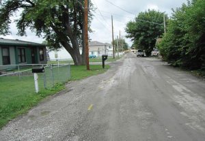 This “before” photo shows a road in the East Manawa neighborhood with gravel runoff and puddling along the road. These types of issues are common in this area and created the need for the city of Council Bluffs to look at some creative ways to deal with them — like porous asphalt. (Photo provided)