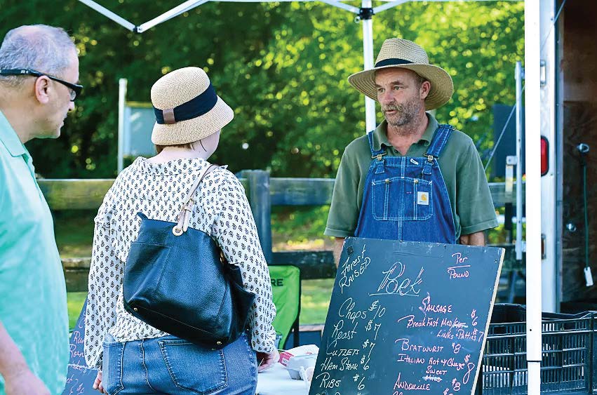 Farmer’s market customers buy forest-raised pork from a Renaissance Farm producer. (Photo provided by Germantown Parks and Recreation)