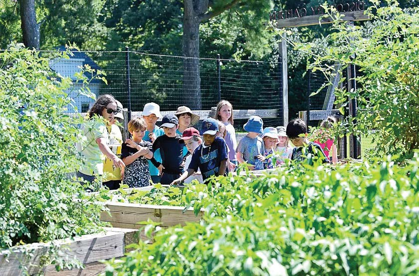 Sarah Blackwell, Germantown Parks and Recreation extended school manager, explains how to grow vegetables in raised beds to school field trip visitors at the Farm Park. (Photo provided by Germantown Parks and Recreation)