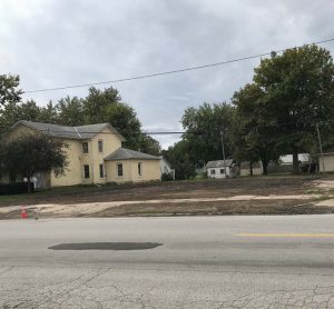 The yellow house, visible in the after photo below, is currently where the library is housed; it will be taken down once the new library is built.