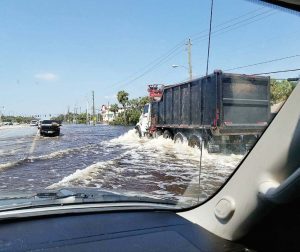 Drivers travel through water left by Hurricane Irma in the Bonita Springs, Fla., area. Floodwaters can contain sewage making them dangerous for people wading through them. (Photo provided)