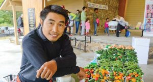 A vendor has set up shop with fresh vegetables at Johns Creek’s farmer’s market, which was held last summer at Mark Burkhalter Amphitheater at Newtown Park. (Photo provided)