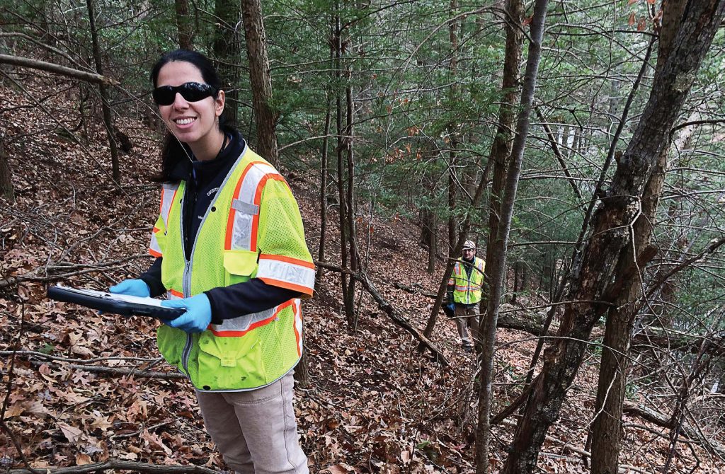 Fairfax County, Va., urban foresters climb a slope to monitor some hemlocks in the county. (Photo provided)