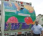 Delbert Bryant poses with one of Greenville’s sanitation trucks, which was part of Greenville’s student art contest. (Photo provided)