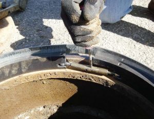 A worker easily adjusts American Highway Products’ pivoted turnbuckle manhole riser using a screwdriver in Milwaukee, Wis. (Photo provided)