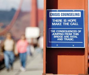 A suicide prevention notice posted on the Golden Gate Bridge. In addition to fencing, suicidal hotline signage can make a difference in suicide prevention. (Shutterstock.com)